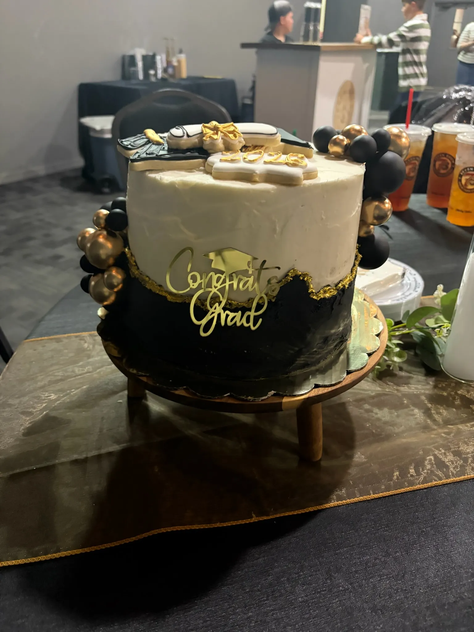 A black and gold graduation cake finished with a gold bow