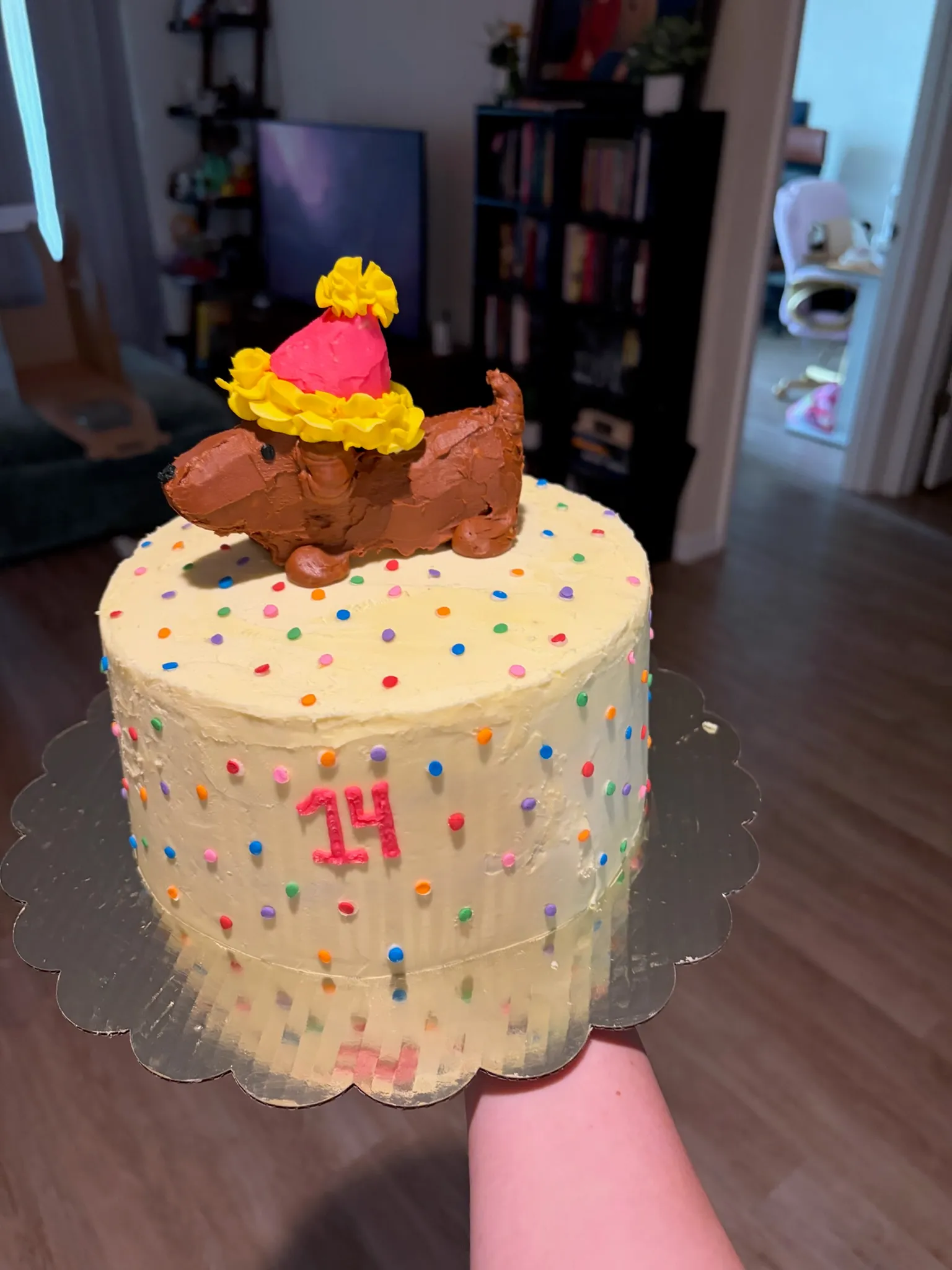 A sprinkle-covered cake topped with a piped ice cream cone