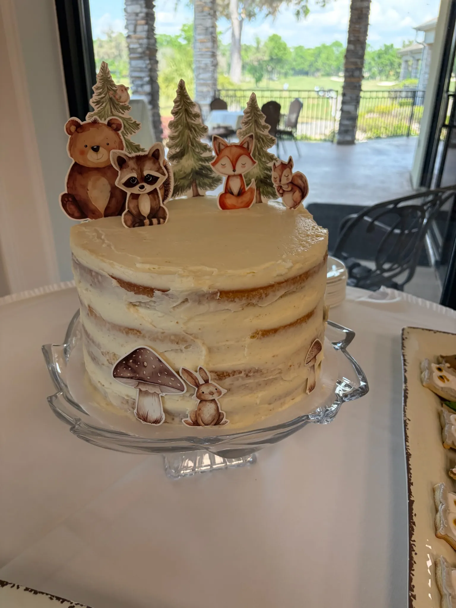 A semi-naked buttercream cake styled for a rustic celebration