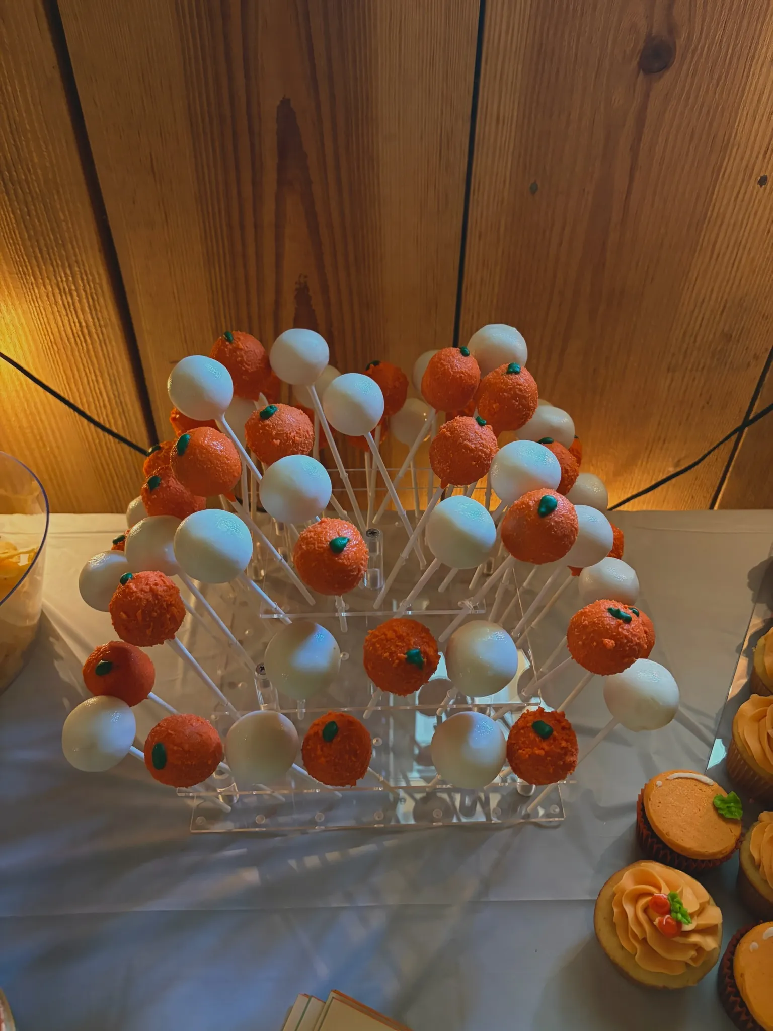 Orange and blue cake pops arranged on a stand