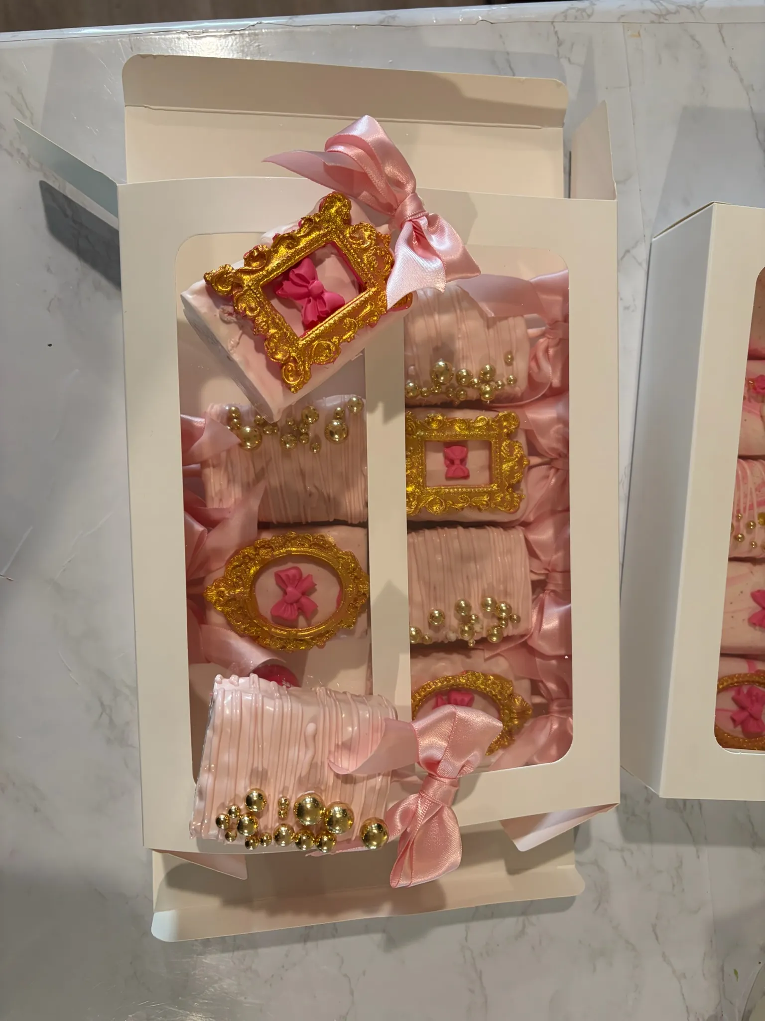 Pink and gold ornate cake pops packaged in a gift box