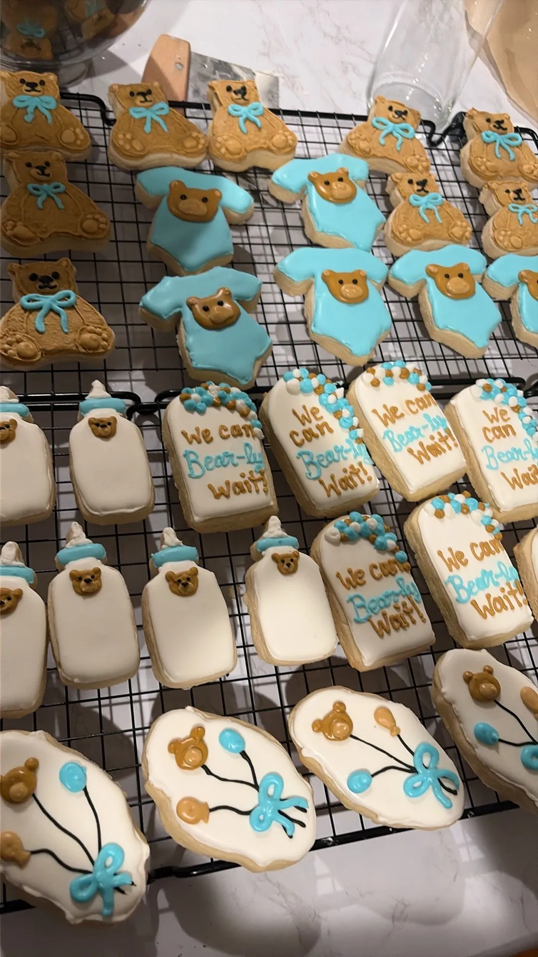 Blue baby shower cookies including onesies and teddy bears
