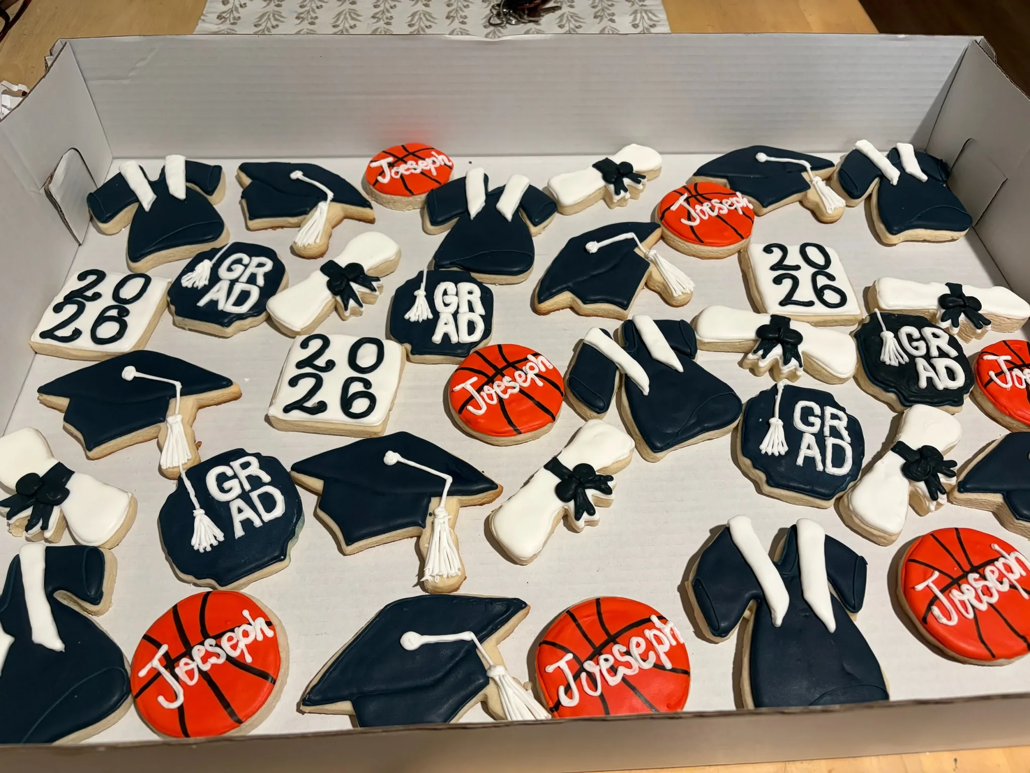 Navy and red graduation cookies with caps, gowns and the year