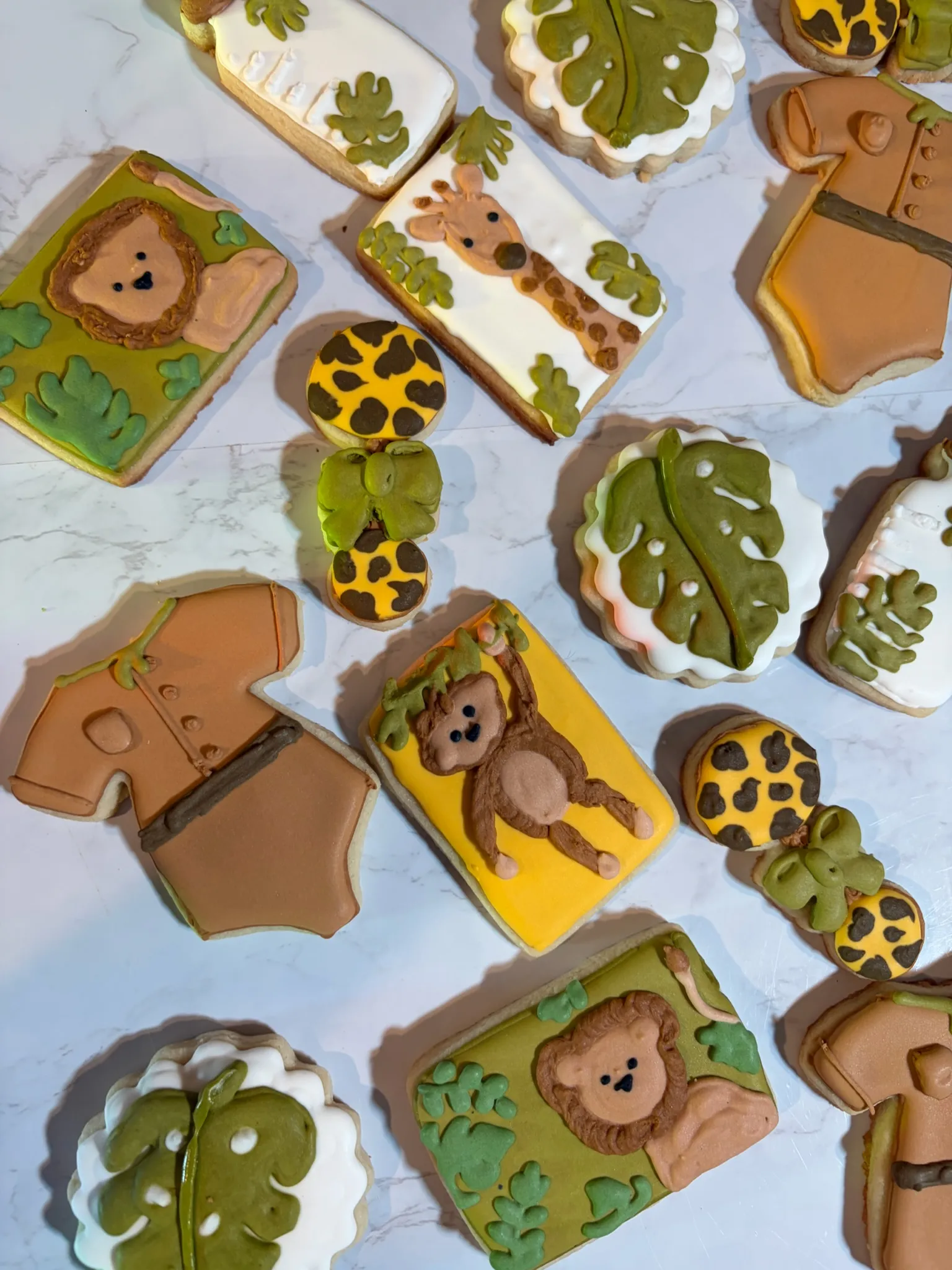 Safari-themed decorated cookies including a giraffe, monkey and leaves