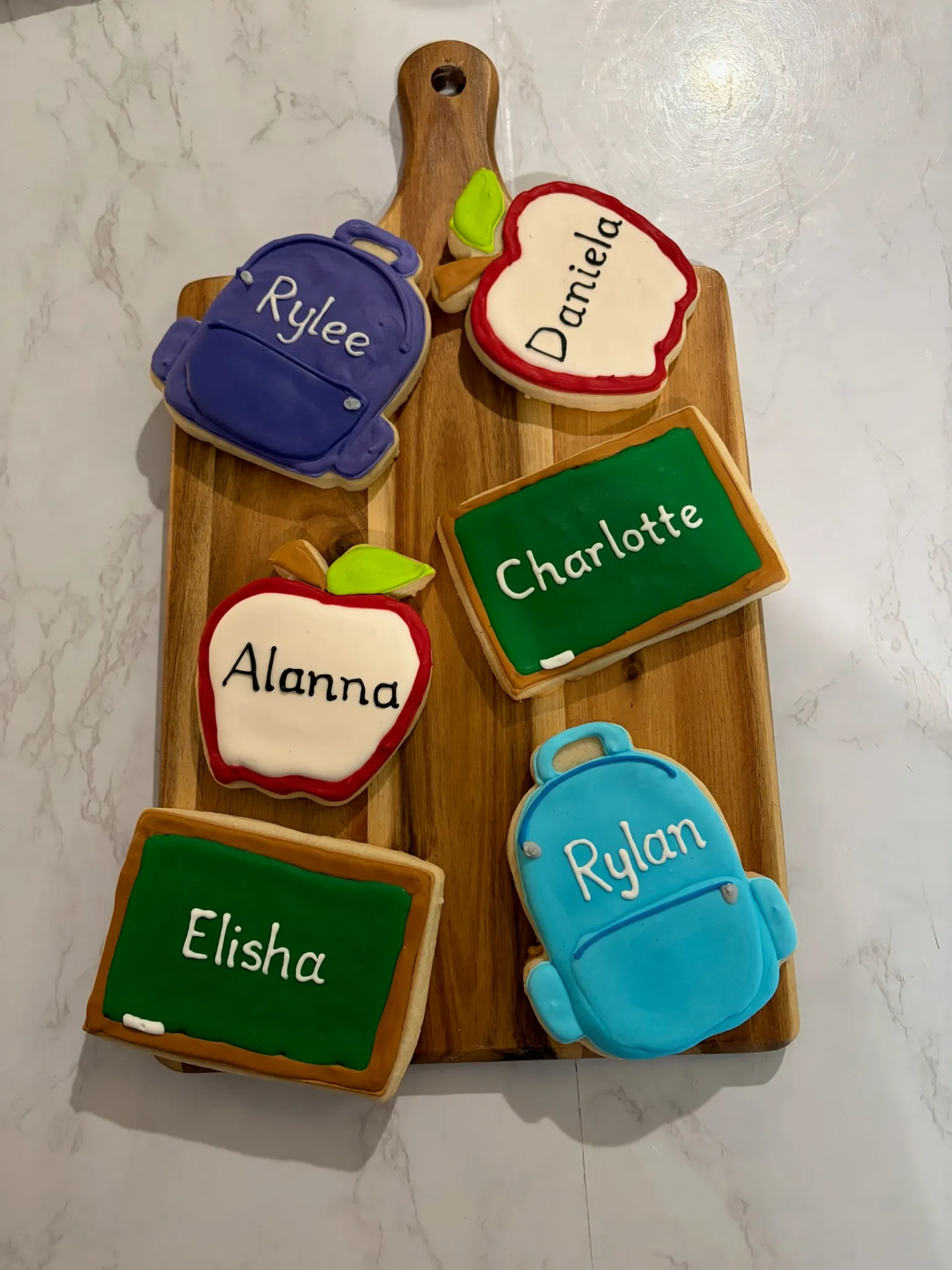 Teacher-appreciation cookies shaped like apples, backpacks and chalkboards