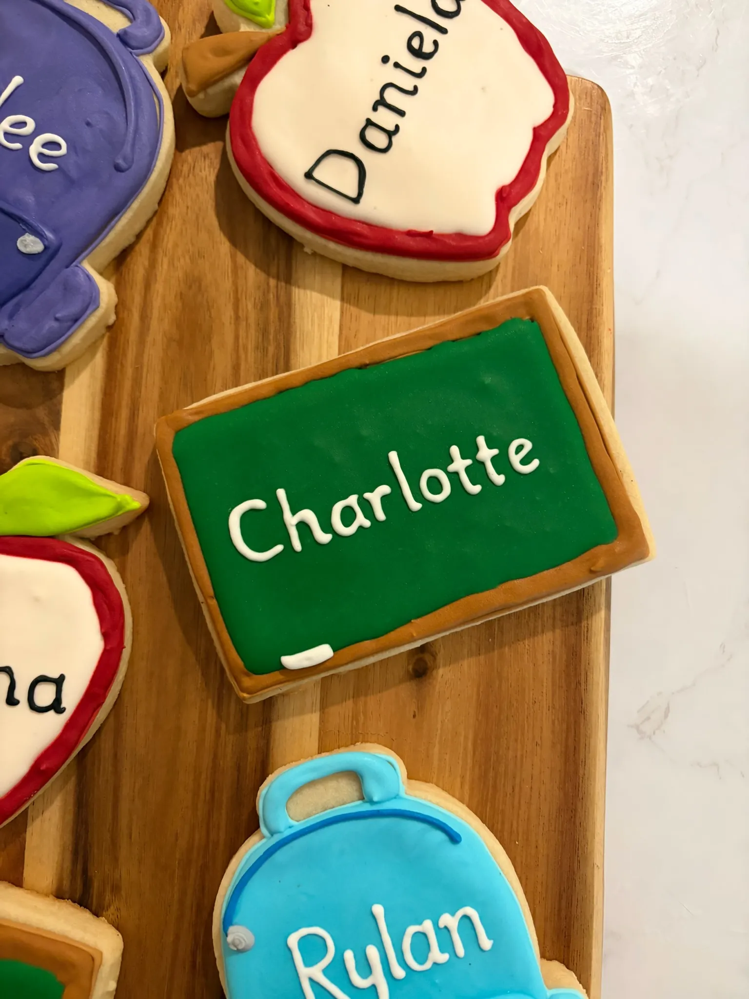 A chalkboard-shaped cookie iced with the name 'Charlotte'
