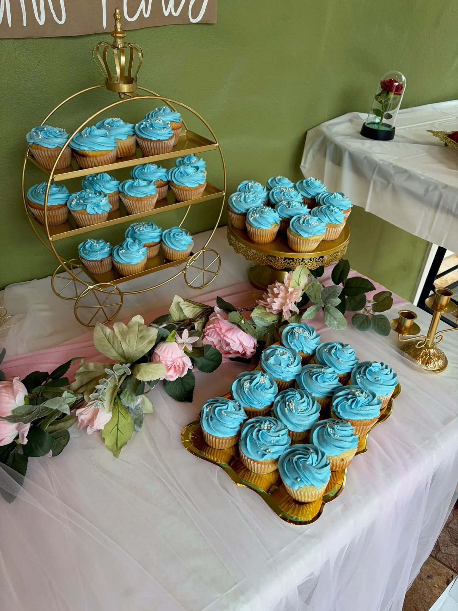 A tiered stand of blue and white cupcakes styled for an event with flowers