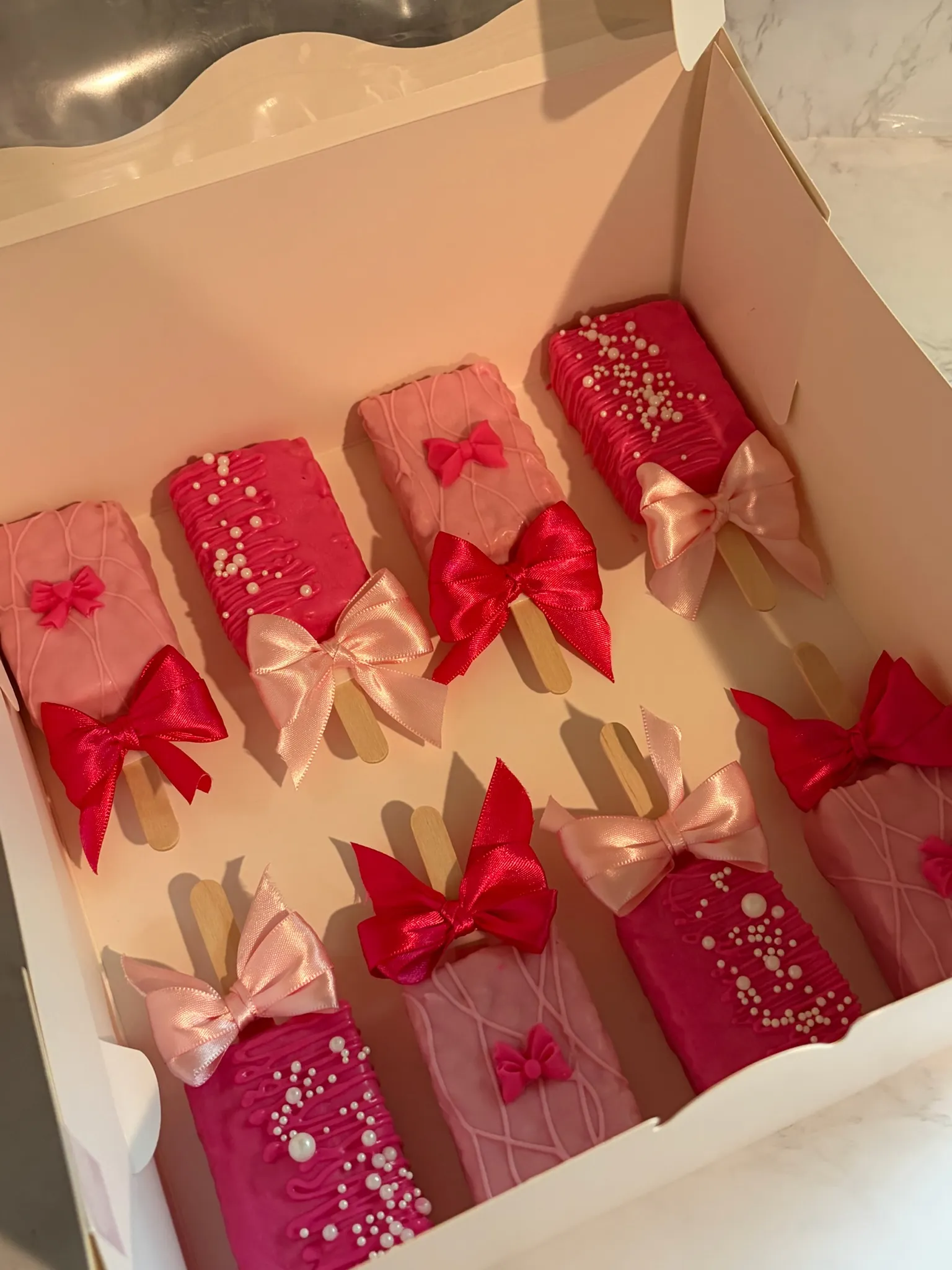 Pink dipped treats finished with piped bows