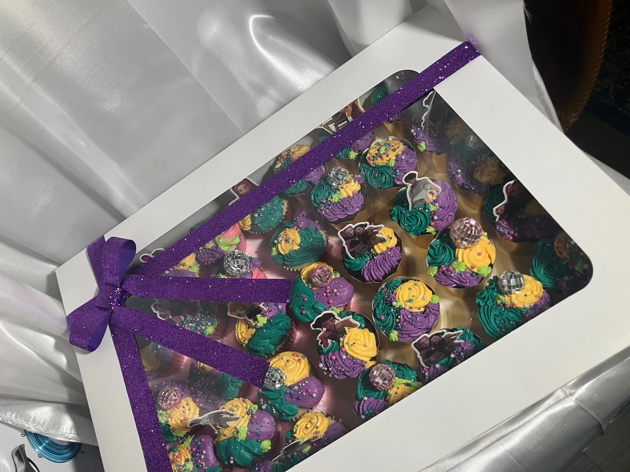 Purple and gold sprinkled treats boxed with a ribbon
